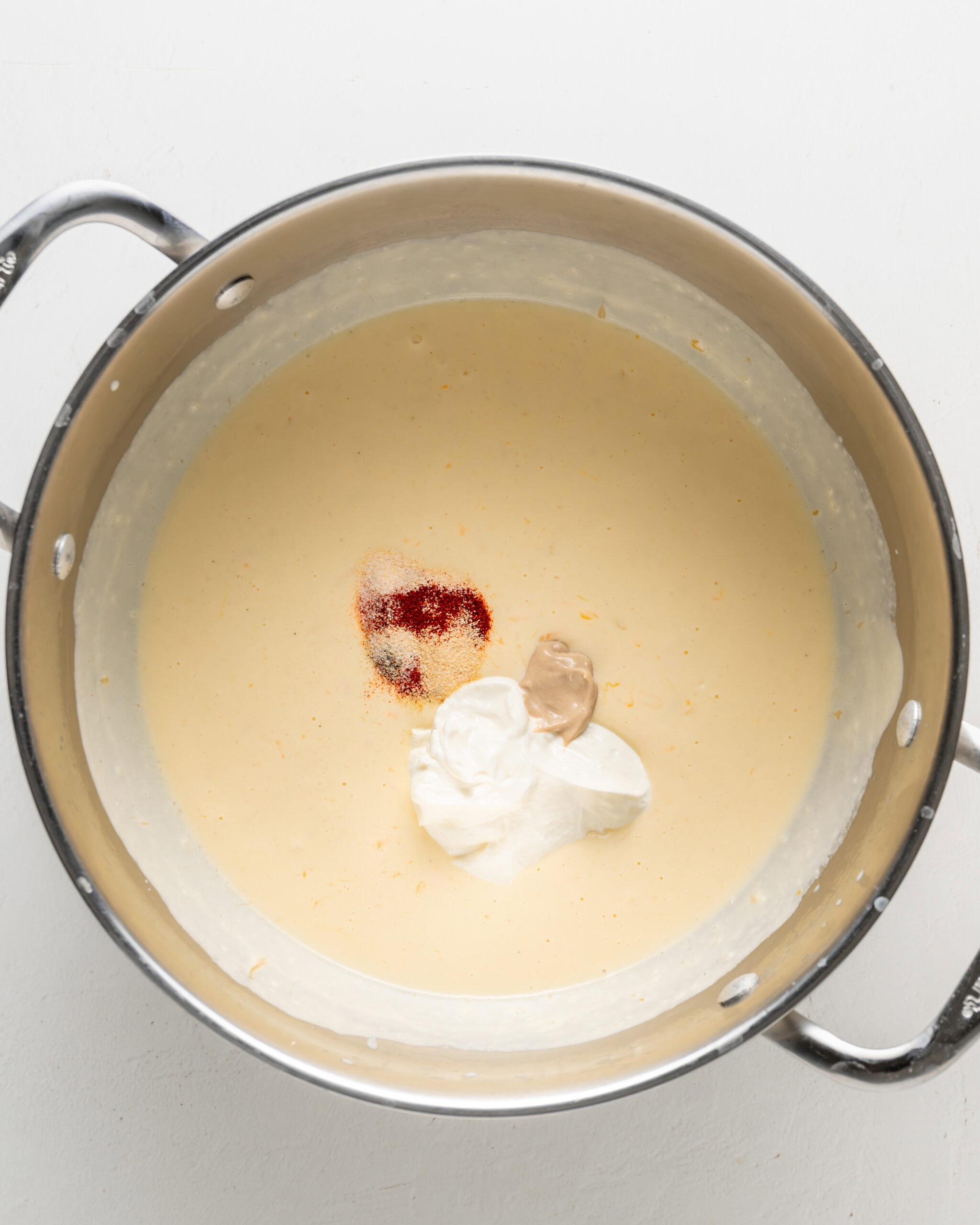 Adding spices and sour cream to cheese