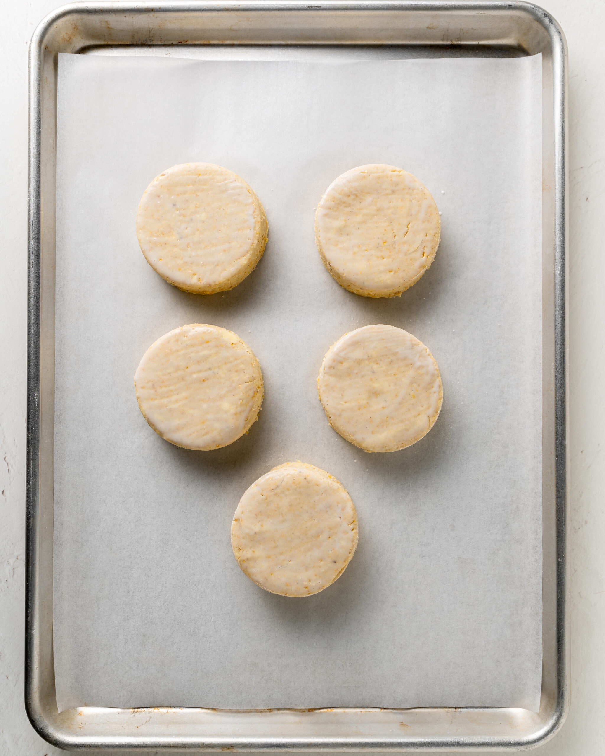 unbaked cornmeal biscuits on baking sheet.