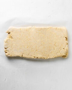 Fold the cornmeal biscuit dough into a rectangle.