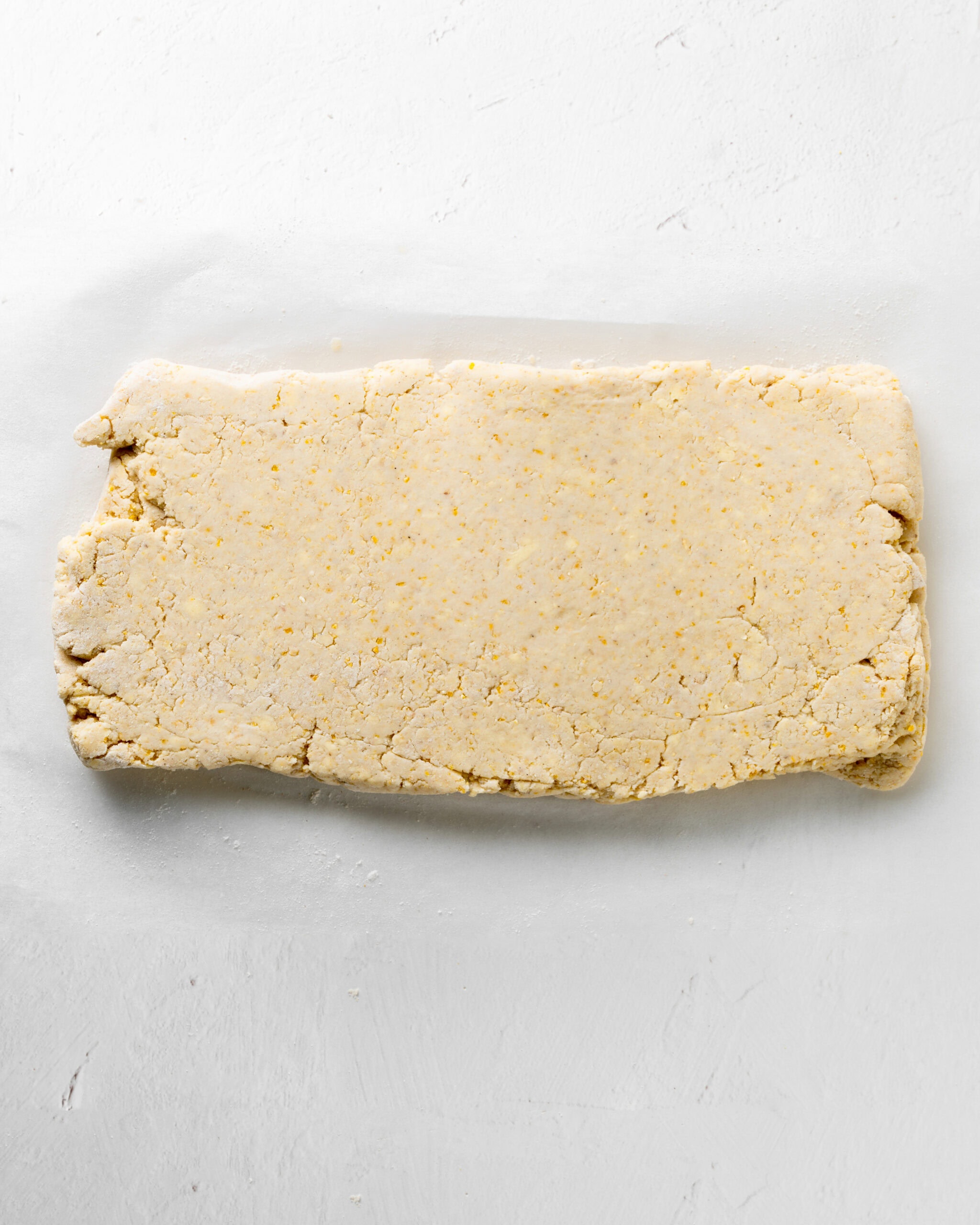 Fold the cornmeal biscuit dough into a rectangle.