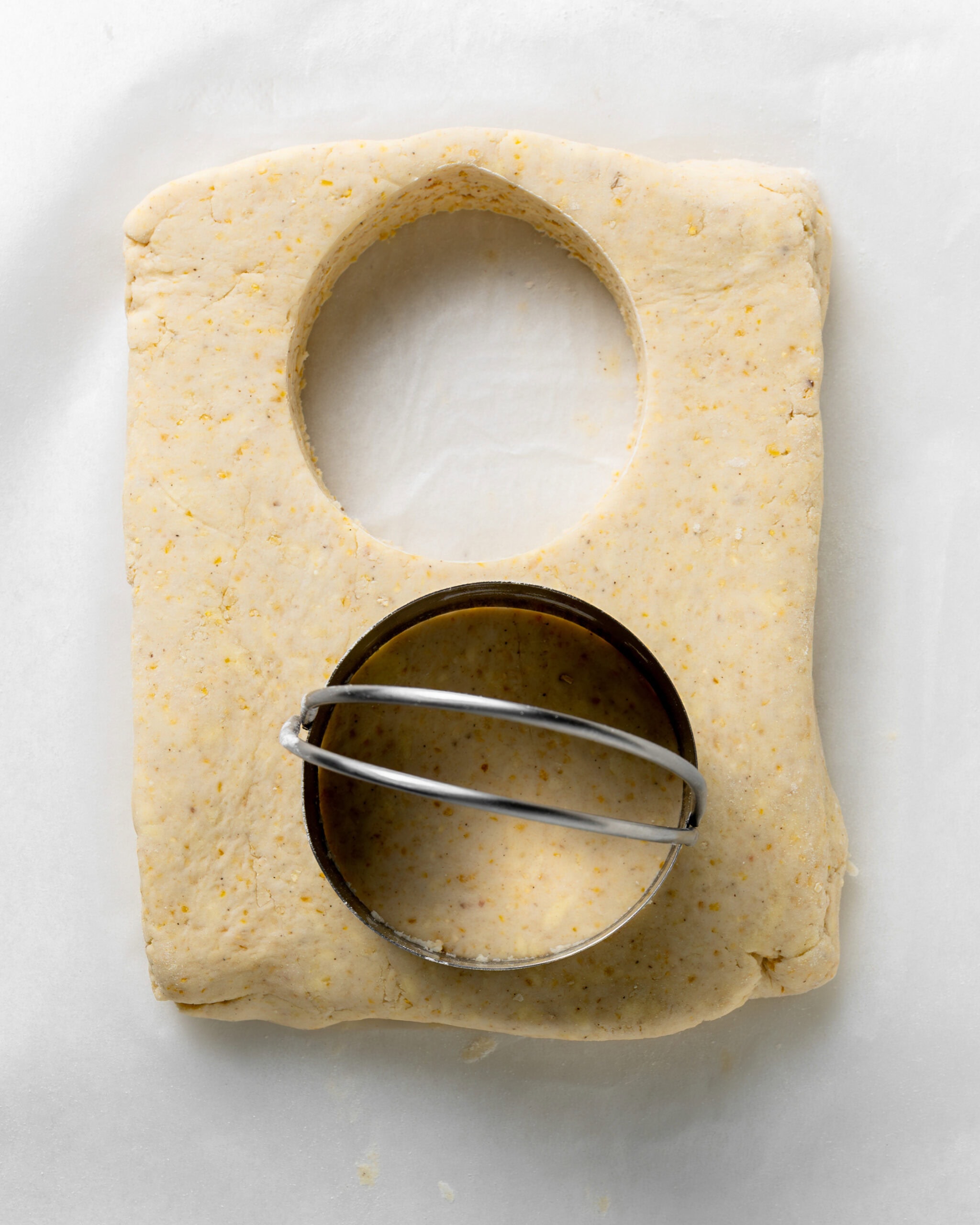 Cutting the cornmeal biscuits with the biscuit cutter.