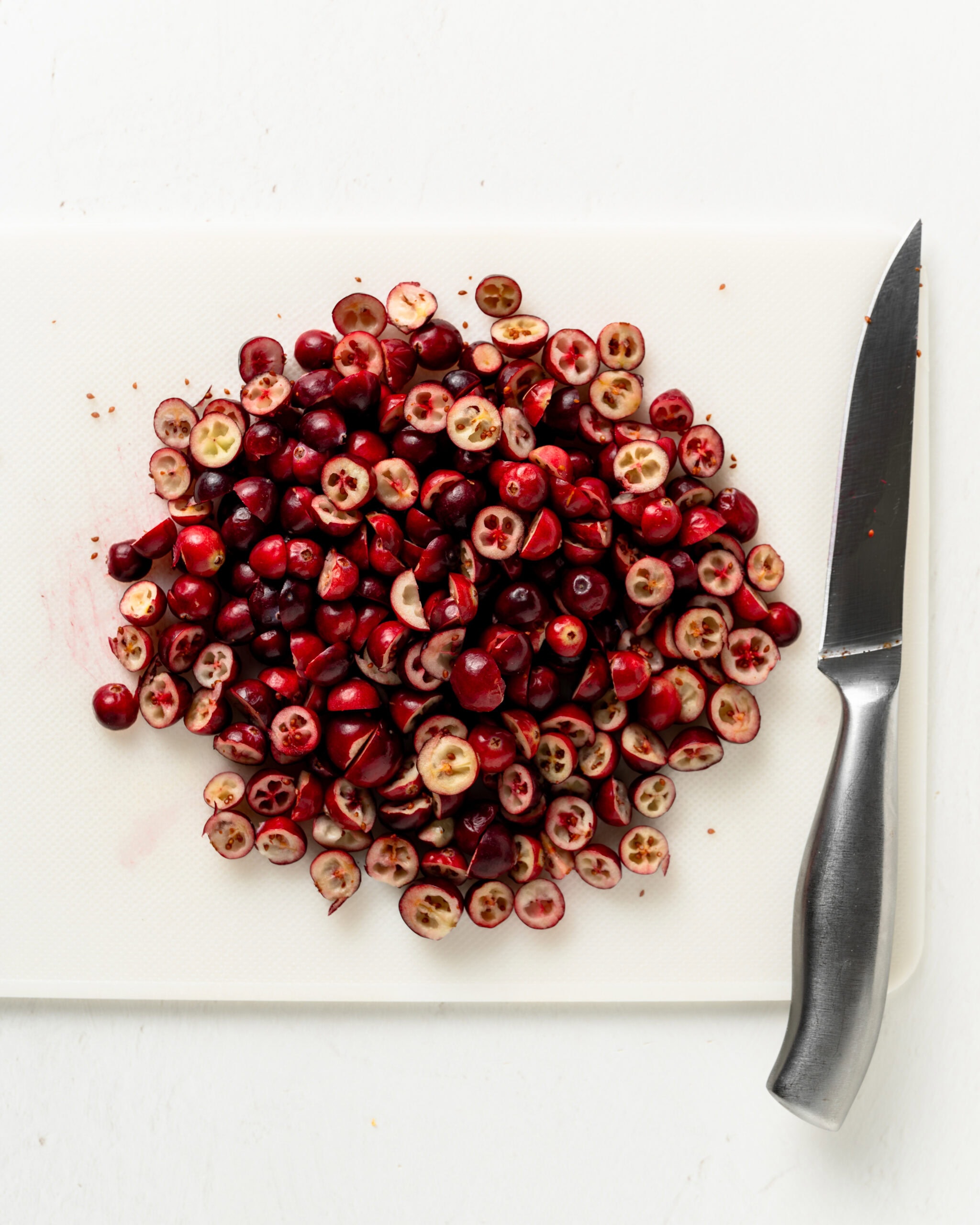 Cutting cranberries in half.