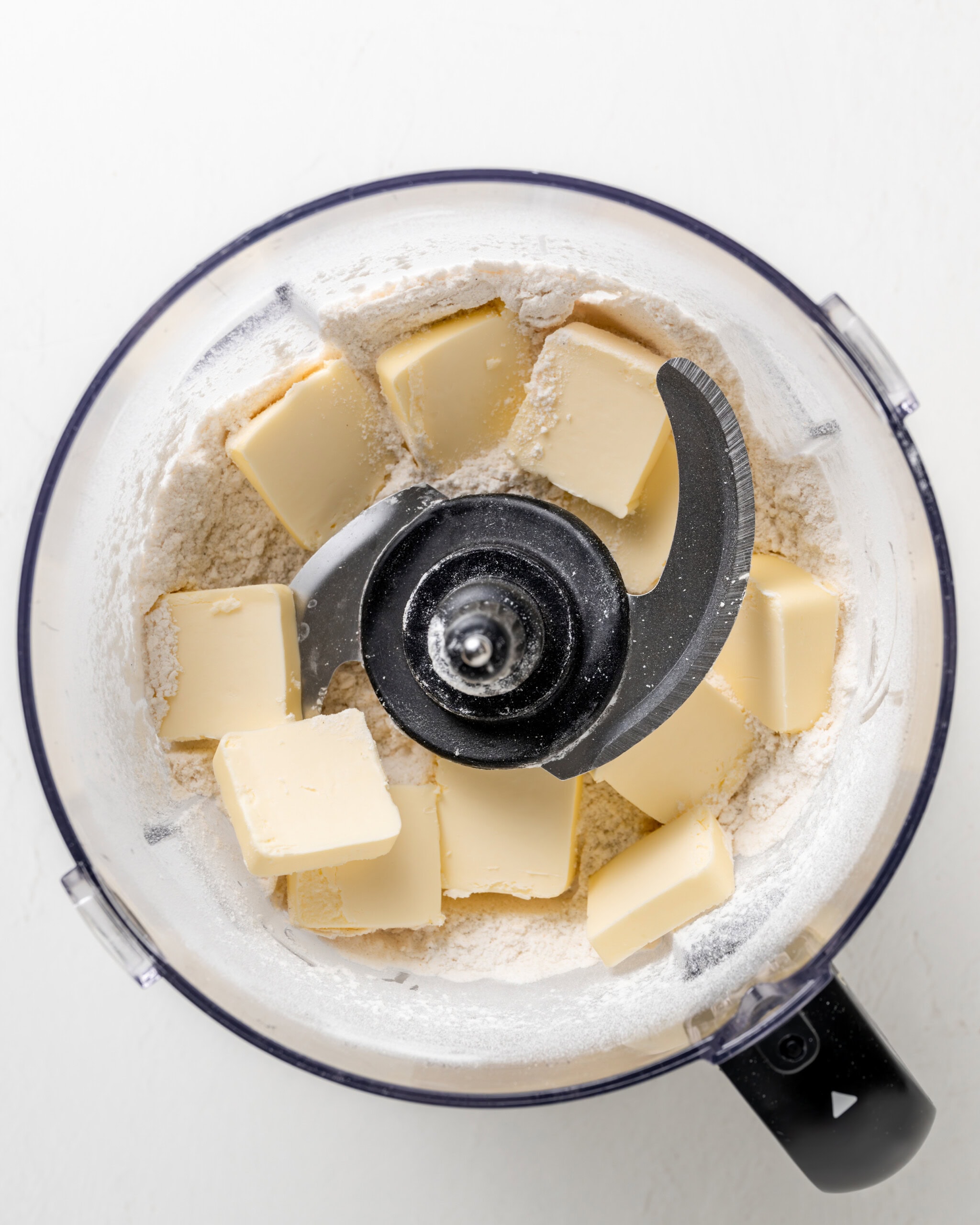 Adding the cubed butter to food processor for scones.