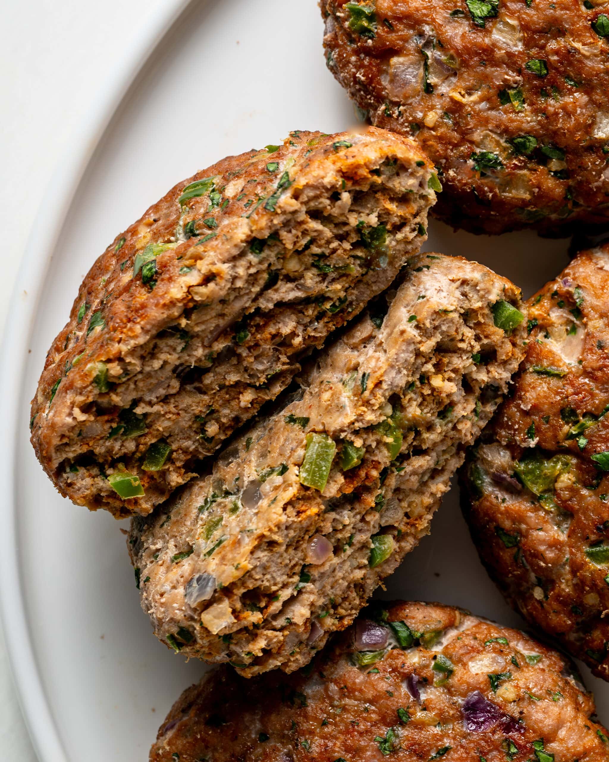 Jalapeno turkey burgers cut in half to show the juicy tender inside.