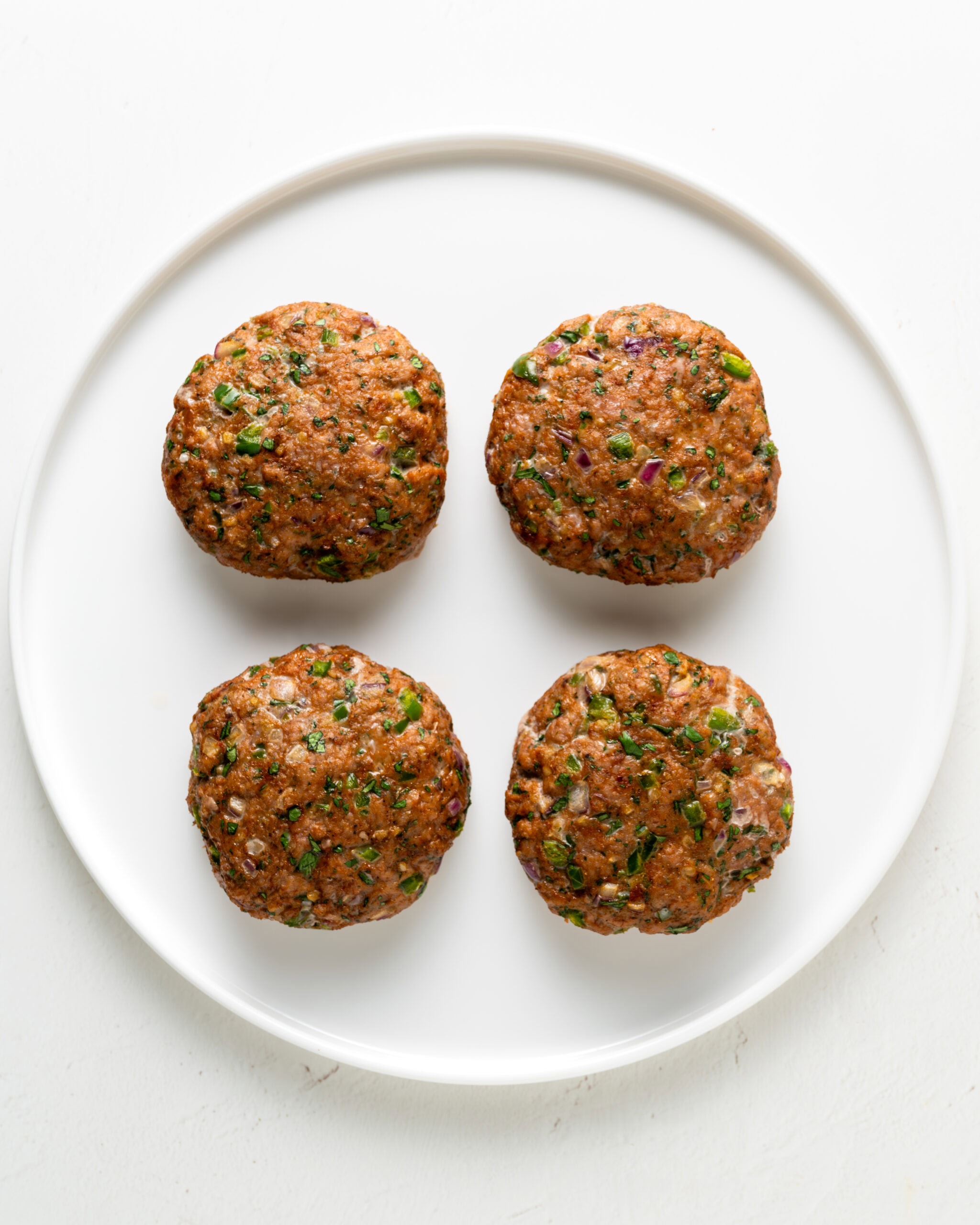 Baked turkey jalapeno turkey burgers on a white plate.