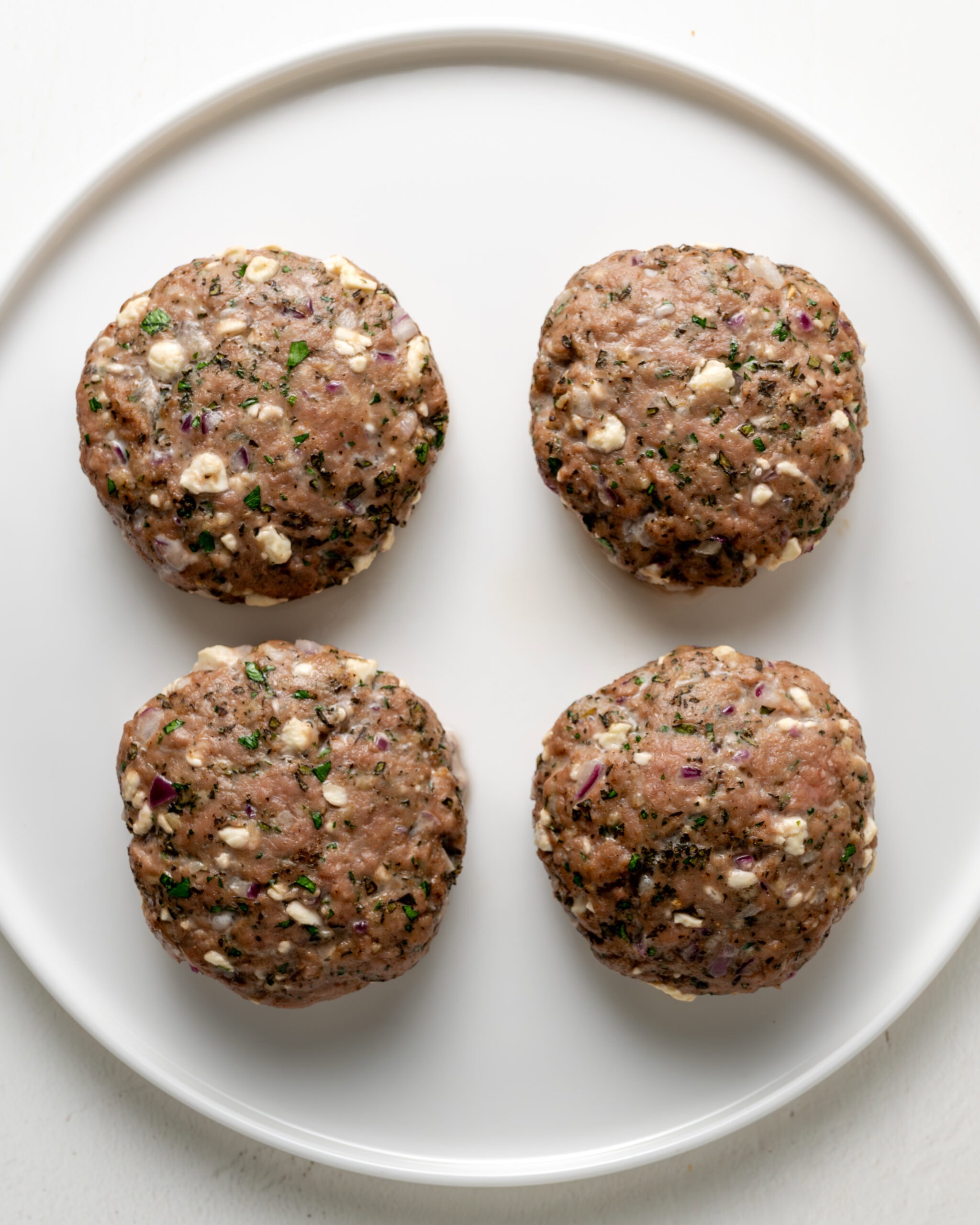 Baked turkey burgers on white plate.