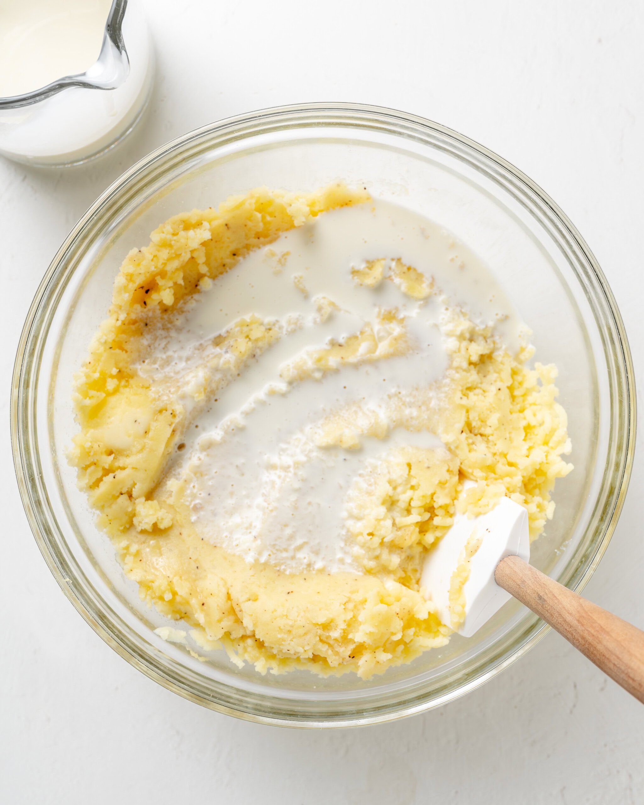 Adding cream to mashed potatoes.