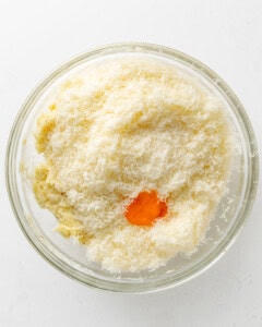 Adding egg yolk and cheese to mashed potatoes.