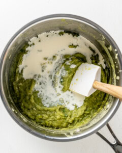 Adding cream and lemon juice to mushy peas.