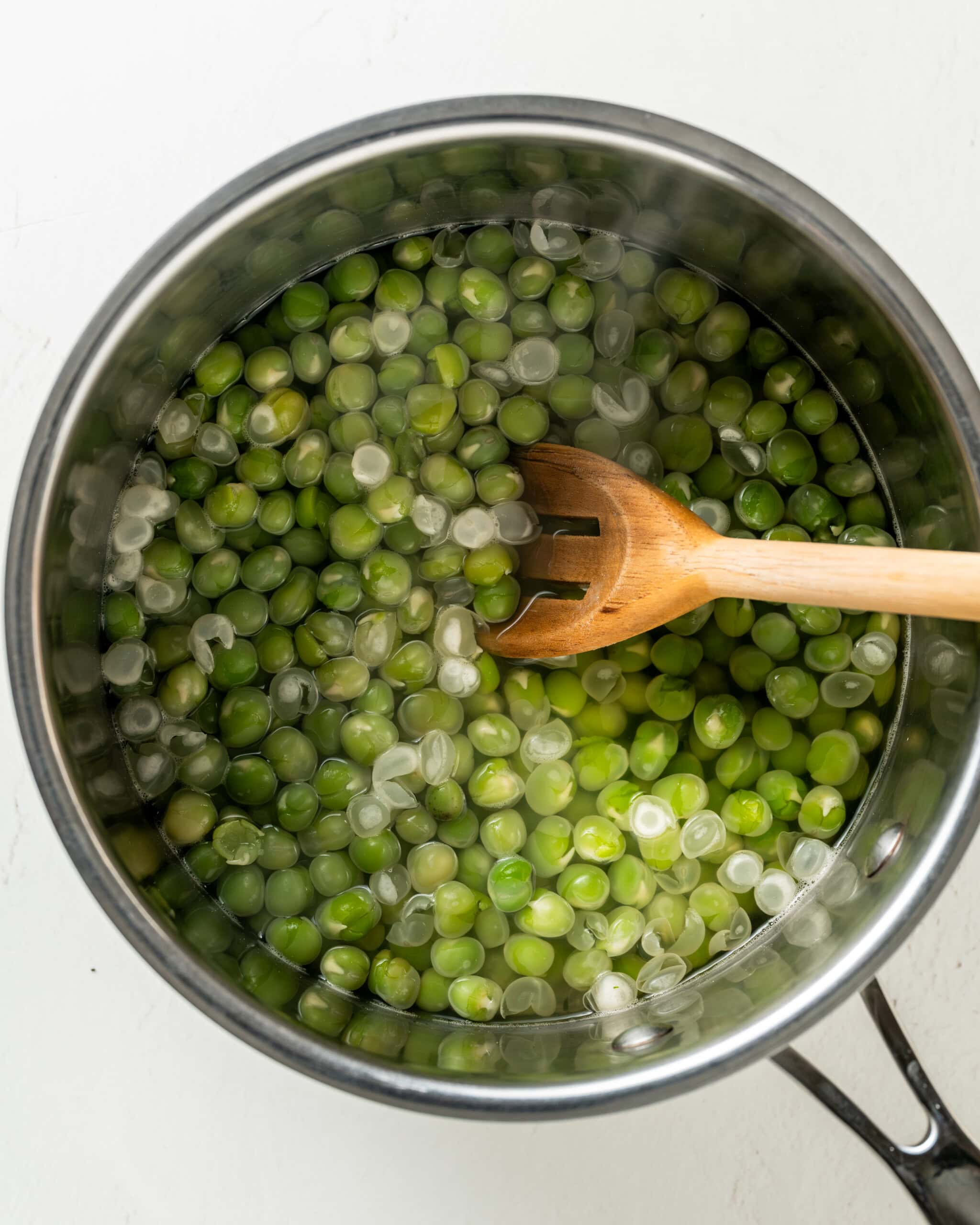 Boiling marrowfat peas and skimming the skins on top of the water.