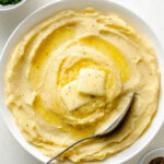 Yukon Gold Mashed Potatoes in a white bowl with spoon.