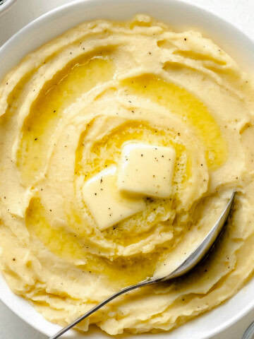 Yukon Gold Mashed Potatoes in a white bowl with spoon.
