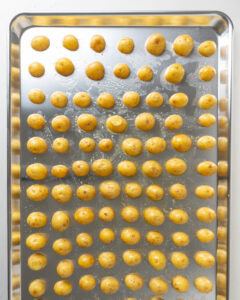 Potatoes on a large baking sheet, cut side down.