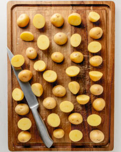 Potatoes on a cutting board cut in half.