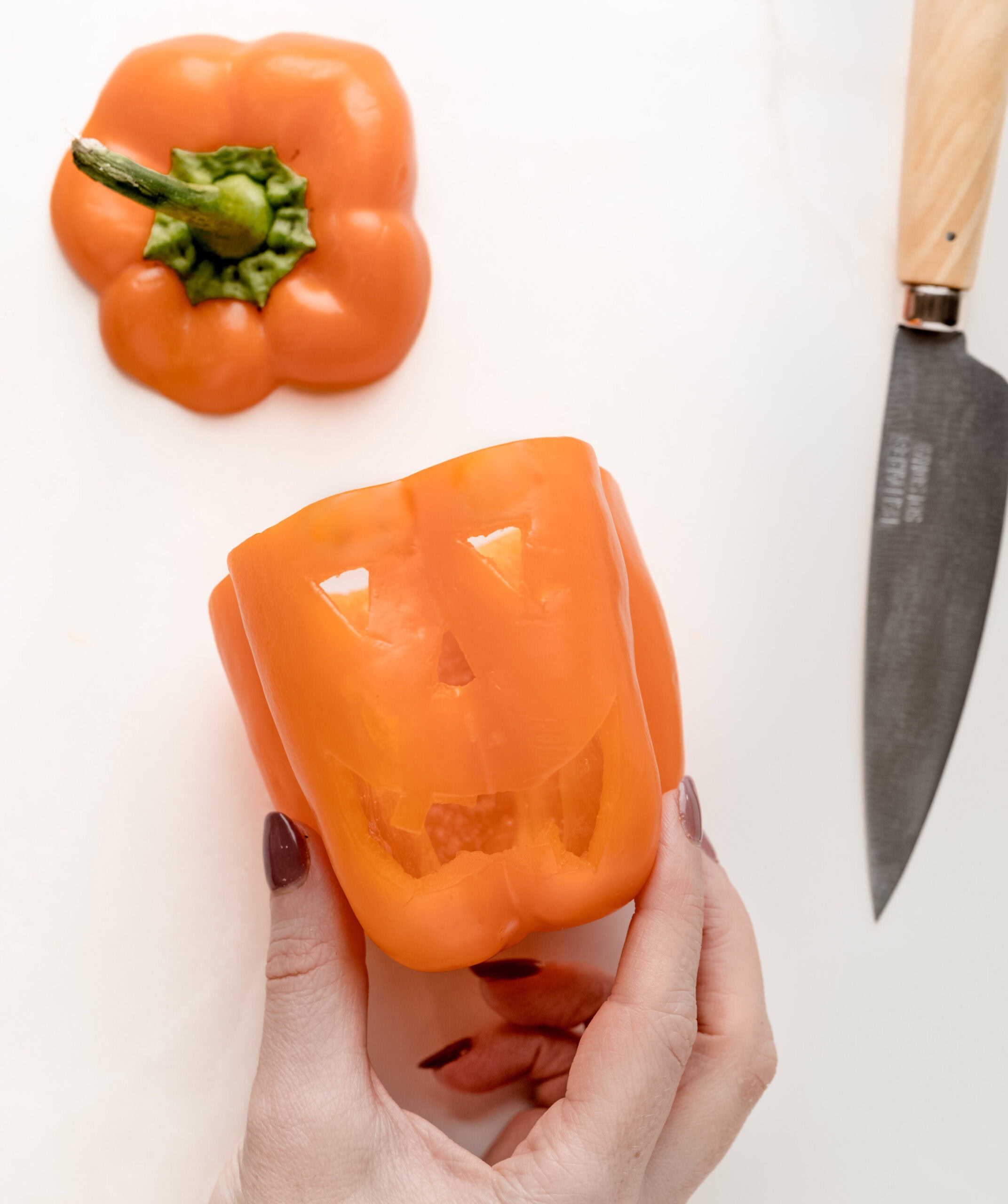 Carving Halloween stuffed peppers, making a jack-o-lantern face.